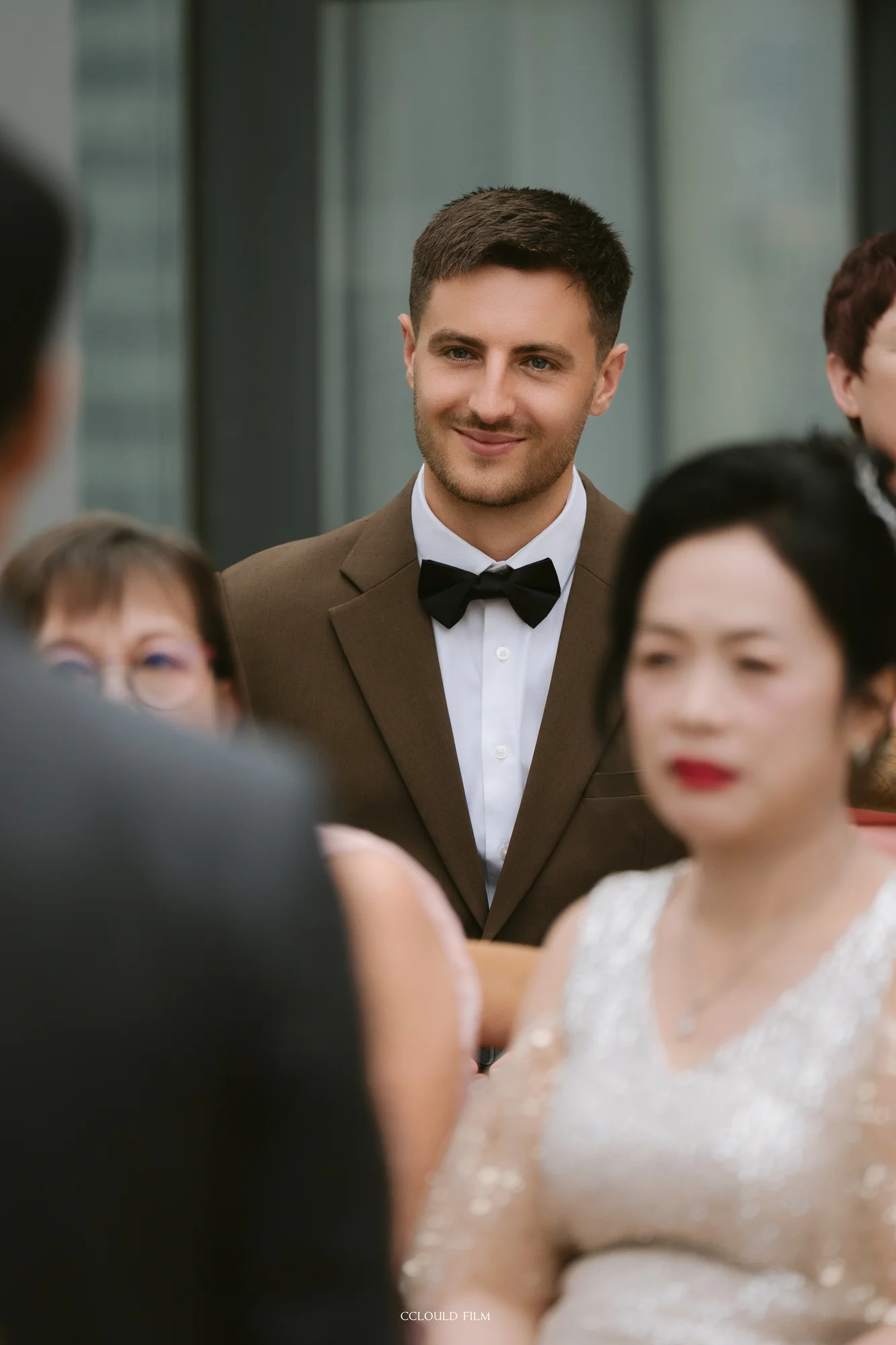 Henry smiling among guests during the ceremony
